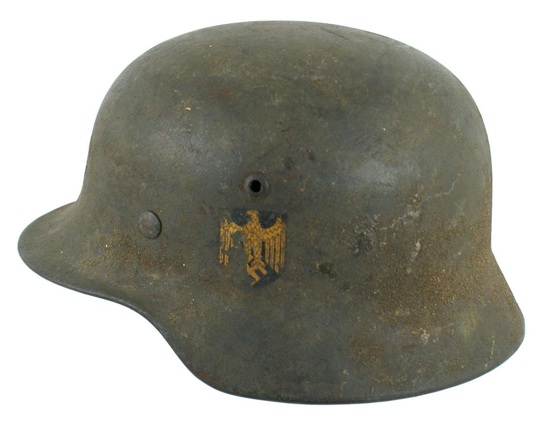 German Navy M1935 single decal helmet: E-029 German Navy M1935 single decal helmet. 50% original green "sand" finish. 80% gold eagle/swastika decal. Original leather chinstrap and worn tan leather drawstring liner. About II