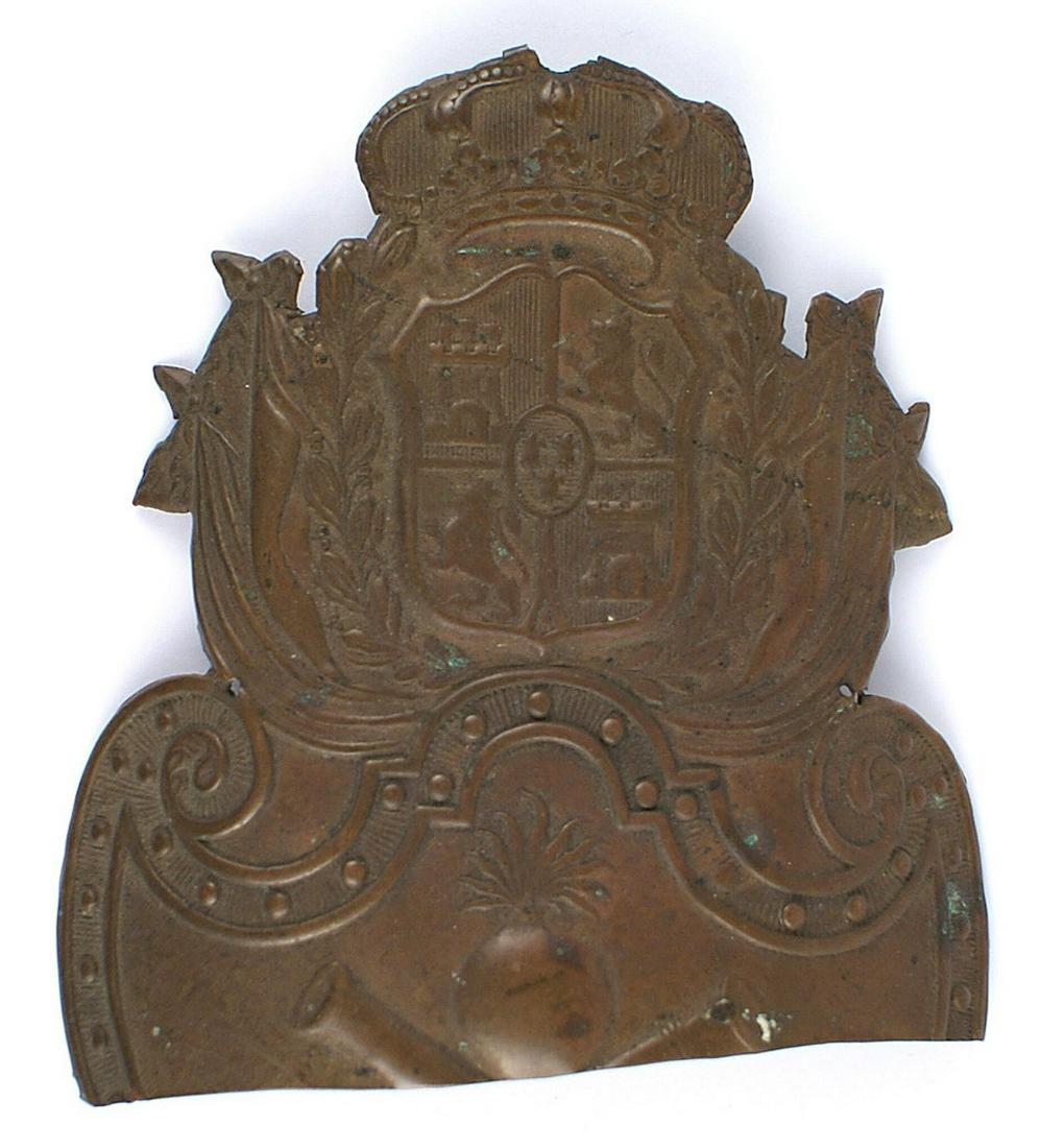 Napoleonic period Spanish brass helmet plate: E-120 Upper section of an Napoleonic period Spanish brass helmet plate. Crowned (missing cross) Spanish coat-of-arms, flags, laurel wreath - above a crescent shield bearing a flaming grenade above cro