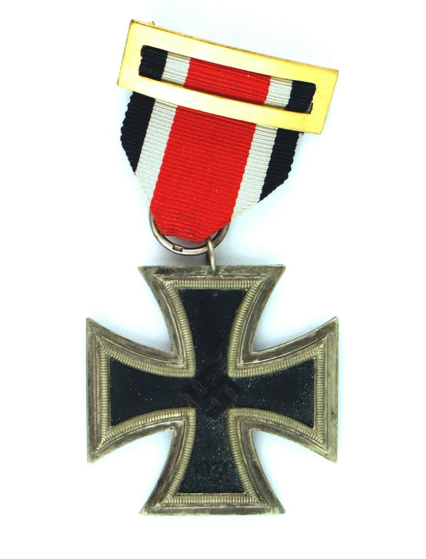German WWII 1939 Iron Cross 2nd Class: B-034 German 1939 Iron Cross - 2nd Class. Aged patina on the silver frame. Ring is stamped "15" (Friedrich Orth - Vienna). Spanish mounted ribbon with a pin-back bar. II+