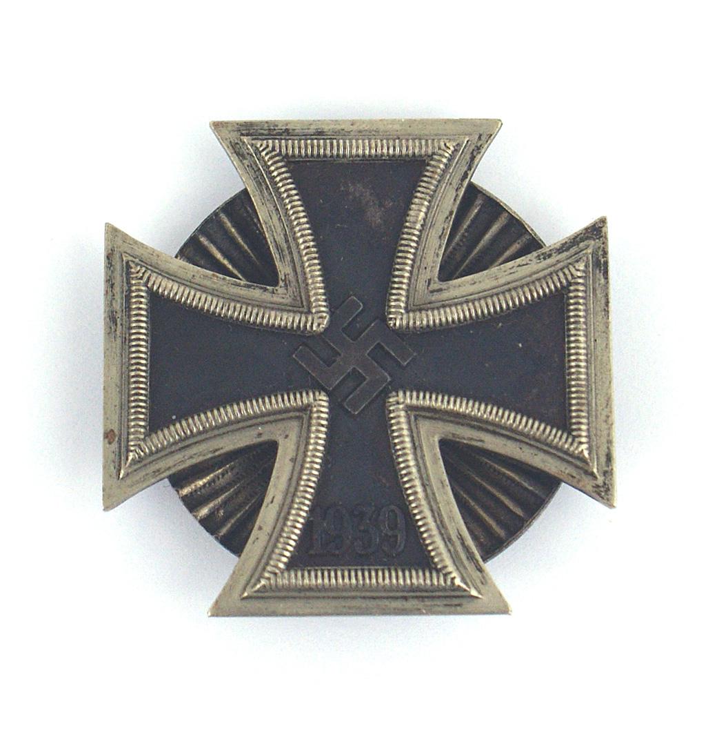 German WWII 1939 1st Class Iron Cross: B-036 German WWII 1939 1st class "screw - back" Iron Cross. Light patina on the silver frame. Relief swastika and "1939" on the black cross. Reverse has a screw post and "sun - rays" spinner. II