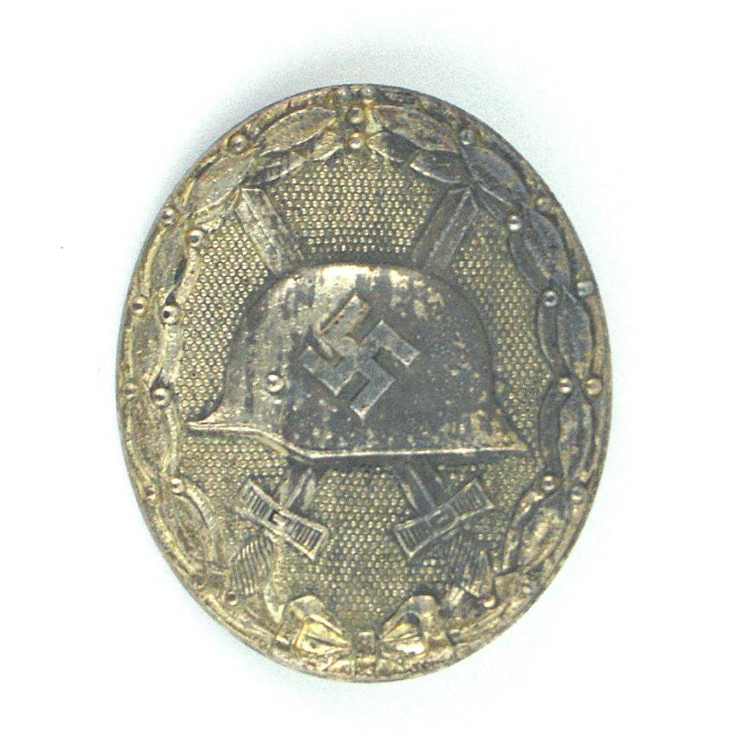 1939 Wound Badge Silver: B-049 1939 Wound Badge - Silver. Solid type. 70% of silver finish remains. Reverse is maker marked "107" (Carl Wild in Hamburg). II