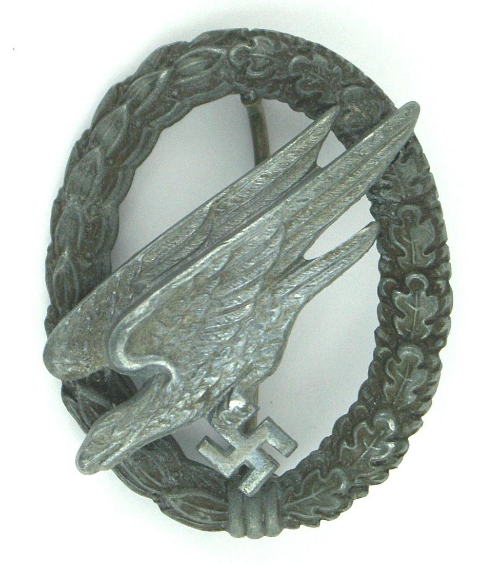 German WWII Luftwaffe Paratrooper Badge: B-062 German WWII Luftwaffe Paratrooper Badge. Well defined diving eagle holding a swastika - mounted on an open oak/linden leaf wreath. Reverse shows two small domed rivets. A quality wartime badge. 