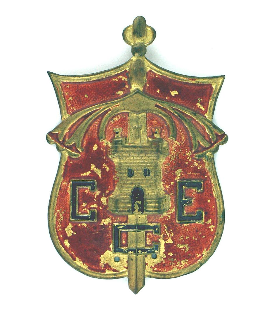 Spanish Civil War Sappers sleeve shield: S-021 Spanish Civil War, Nationalist Sappers convex metal sleeve shield. Relief age toned medieval broad sword, castle turret and blackened letters "CCE". 3" x 2 7/8". II