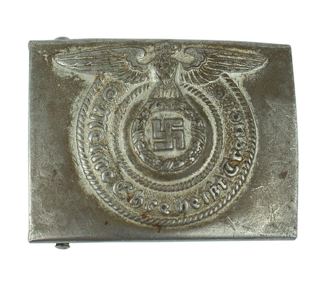 German WWII Waffen SS EM belt buckle: H-023 German WWII Waffen-SS EM steel belt buckle. High relief eagle/swastika and "Meine Ehre Heisst Treue". 20% original silver- gray finish around eagle's wings/swastika/motto. Reverse marked "RZM36/