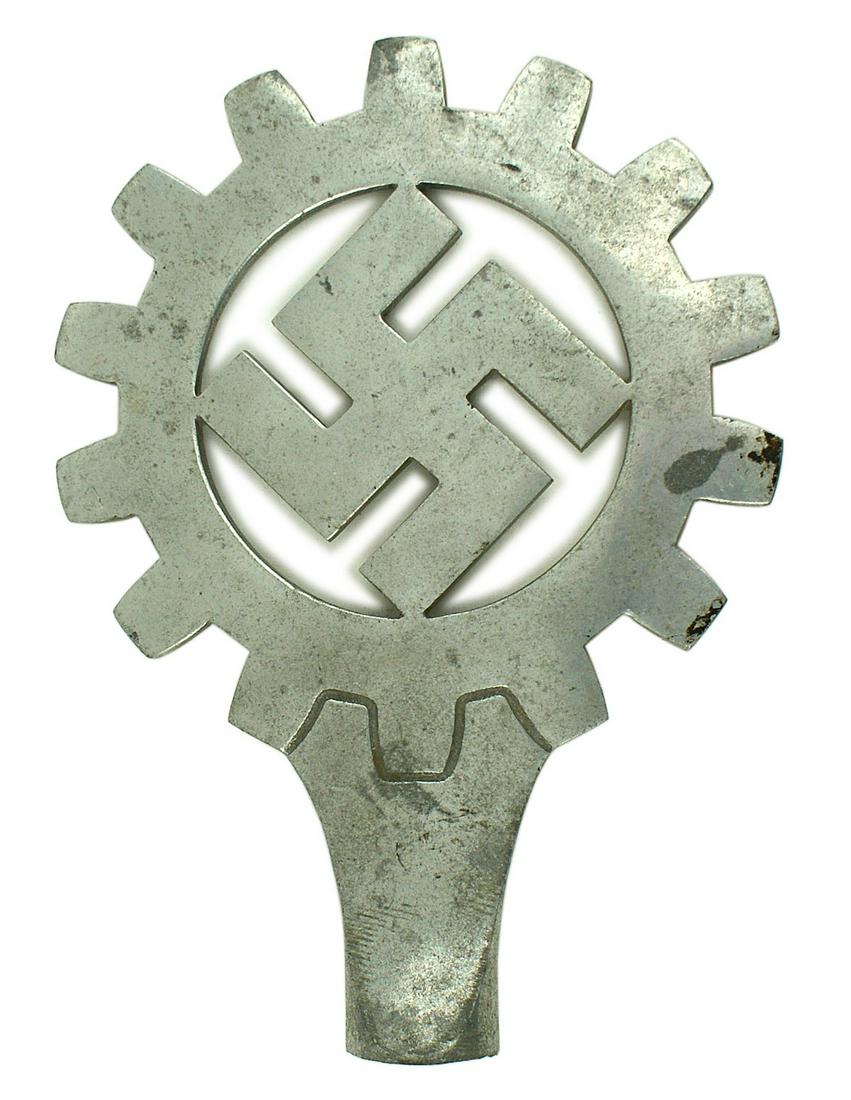 German WWII DAF German Labor Front pole top: H-068 D.A.F. (German Labor Front) pole top. Age toned one-piece polished aluminuMopen cog wheel holding a tilted swastika. Tapered base - is drilled to accommodate a screw attachment for the pole. II