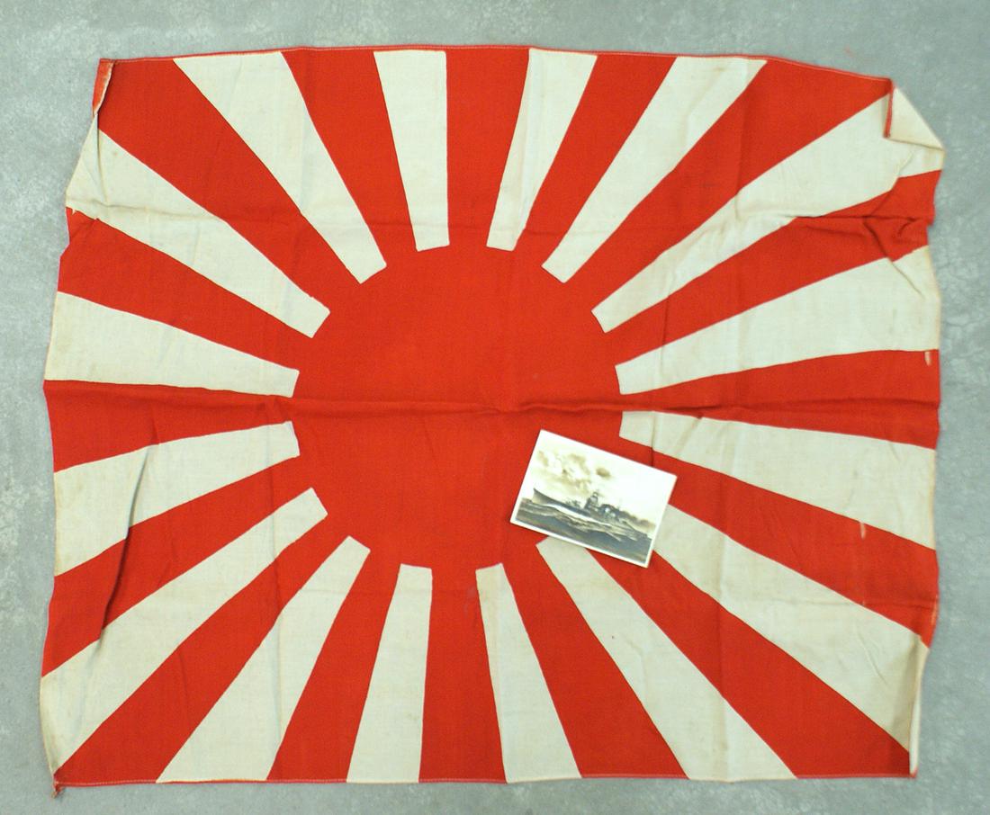 Japanese WWII Navy rayed battle flag: H-114 Japanese WWII Navy rayed battle flag. Age toned white background with red rays emanating from a red disc closer to the hoist side of the flag. 23 1/2" x 28". Very good condition. Also, with a 3"