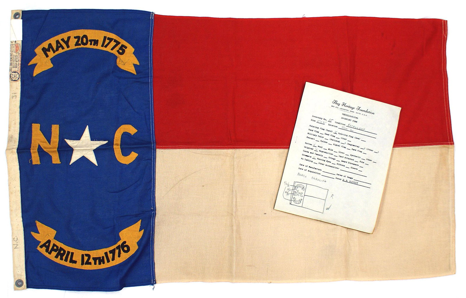 US State flag of North Carolina: K-047 State flag of North Carolina. Vertical 24 1/2" x 11 1/2" blue panel with May 20th 1775 - N (star) C" and "APRIL 12th 1776". Also two 11 1/4" x 25 1/2" horizontal panels, the upper red and the bo