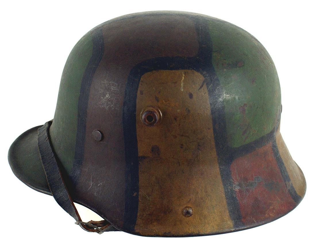 German WWI M1916 camouflage helmet: E-028 German WWI M1916 camouflage helmet. Brown/green/tan/reddish panels divided by black lines. Original off white leather liner consisting of three, double-tongue "pockets", each holding a pad. Blac
