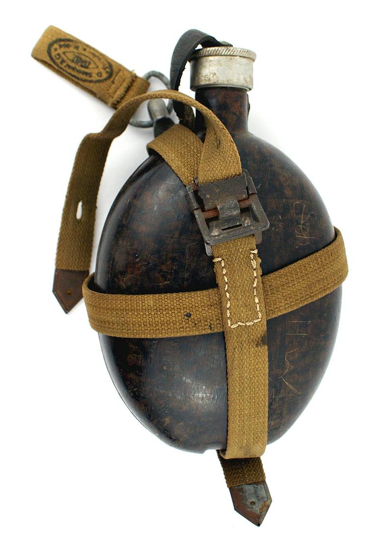 German WWII Afrika Korps canteen: N-002 German WWII Afrika Korps canteen. "Coconut" type body with an aluminum screw on cap. OD web harness with a belt snap/"D" ring/belt loop. Maker marked. II