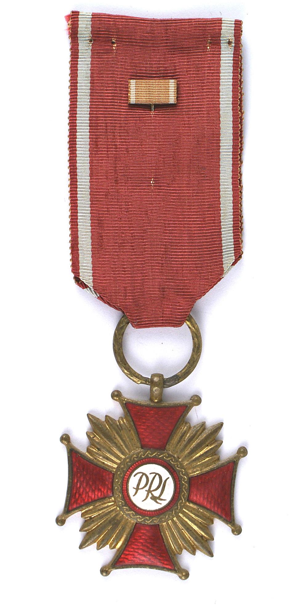Poland Cross of Merit 1st Class: B-170 Poland. Cross of Merit. 1st Class. Same as above but post-war with connected rays. Enamel is perfect. Large laurel leaf suspension ring. With a lapel stick pin ribbon bar. II