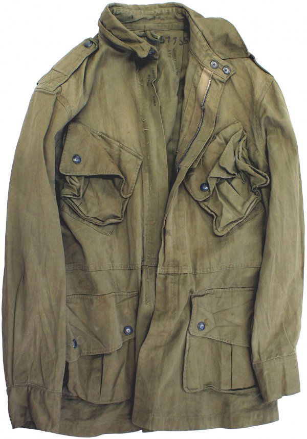 U.S. WWII Parachutist jump jacket: F-115 - Parachutist jump jacket. O.D. cotton with four snap flap pockets. Zippers are missing from the knife pocket as well as the stitching. The right side of the main zipper is missing. Snap buttons