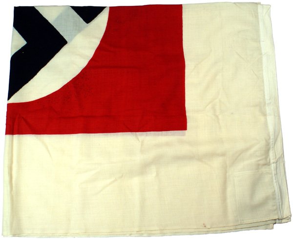 German WWII Naval signal flag: H-106 - Naval signal flag. Printed black "tilted" swastika on a white disc - within a red 35" x 46" rectangular field with an 11" white border. Reinforced corners. Sleeve is stamped "Sig. Fl. Delta na