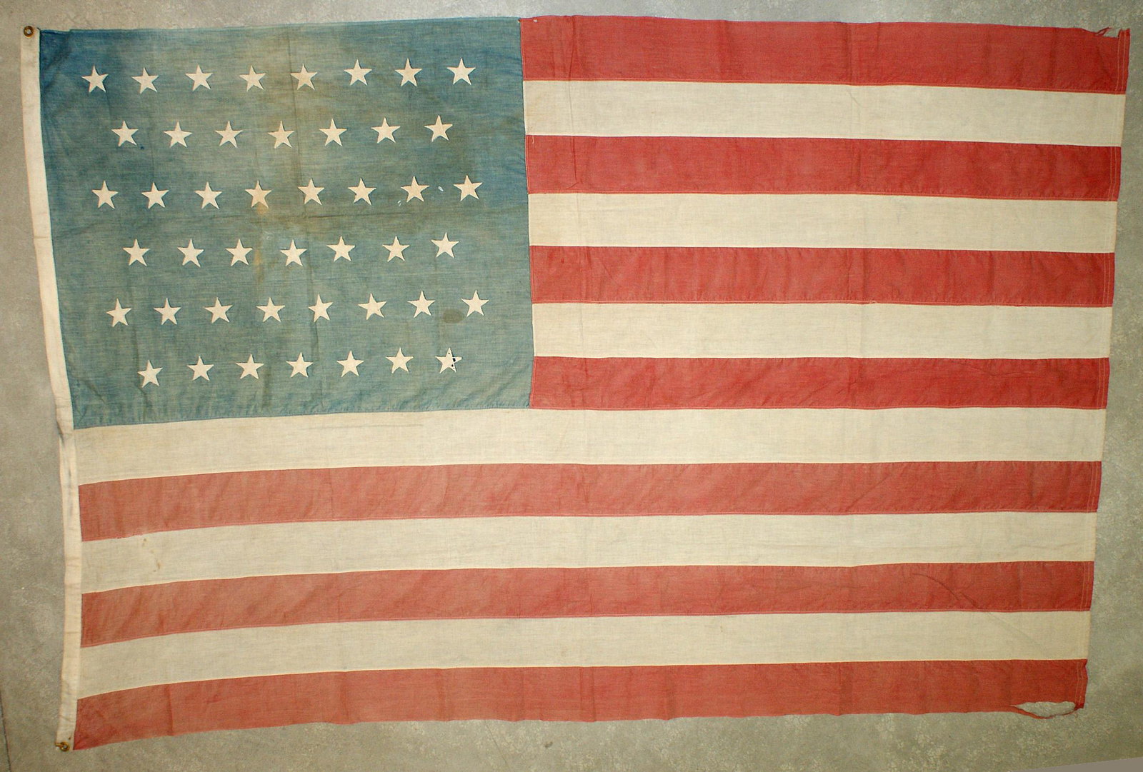 US 45 Star Flag Utah 1896: K-059 US 45 Star Flag (Utah 1896). Stars are all separately machine sewn to the blue canton. 4" wide machine sewn stripes. Border has a period ink name "Amy. N. Wylie". Overall flag shows use and wear