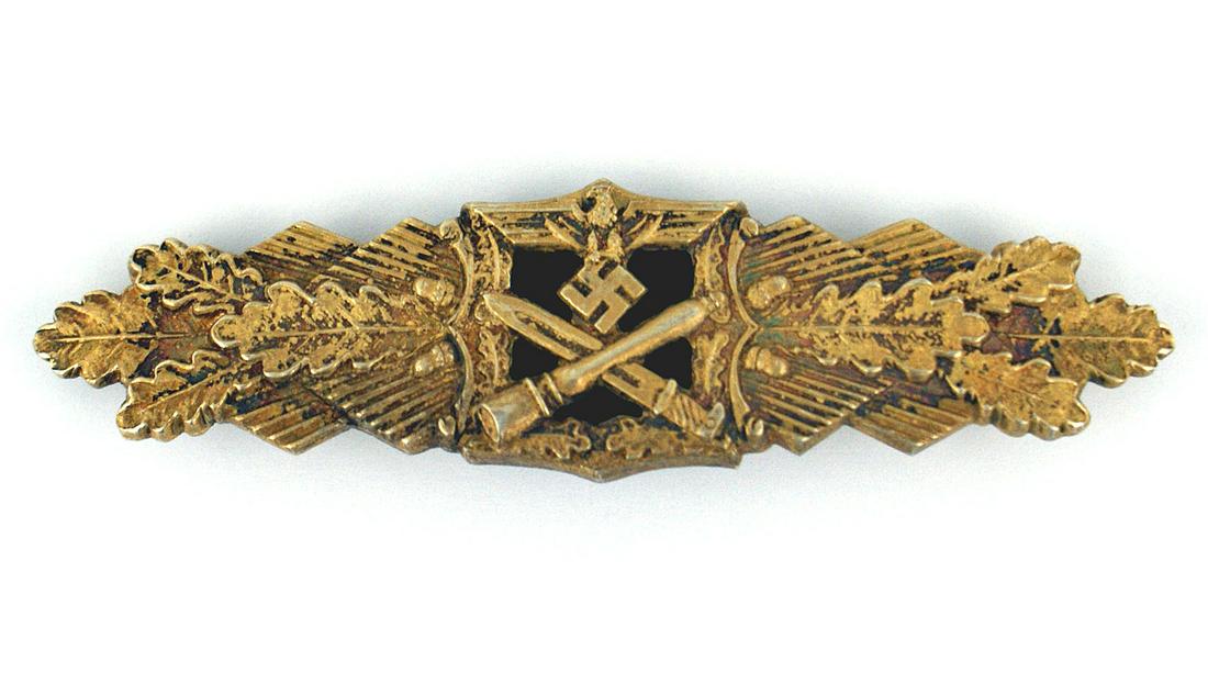 German WWII Close Combat Bar in Gold: B-080 German WWII Close Combat Bar in Gold. Eagle/swastika above an open center bearing crossed bayonet/grenade - all on a blued backing plate flanked by a spray of oak leaves. Reverse marked with mak