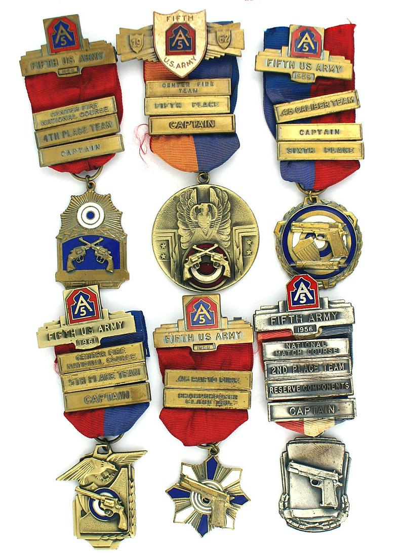 Six 5th Army shooting medals 1956-1962: B-174 Lot of six 5th Army shooting competition medals between 1956 and 1962. All elaborate graphic designs incorporating a .45 automatic or .38 Smith & Wesson into the enameled/silver medal. The pin-b
