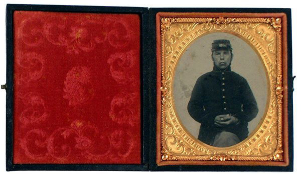 Tintype of seated Civil War solider: K-126 Tintype of the same seated solider as above – but a slightly different pose. 3 1/4" x 2 3/4". Gold frame with an added gold "rope" border. "Gutta-percha" case. II+