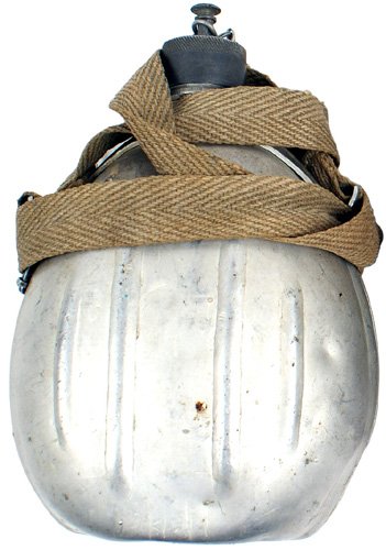 Italian WWII canteen used by American POW: N-35 WWII Italian canteen – used by an American prisoner of war. Standard metal type with a cap/chain and cloth shoulder strap. Reverse of canteen is etched "North Africa – PVT. FRED WARNER 1943" 