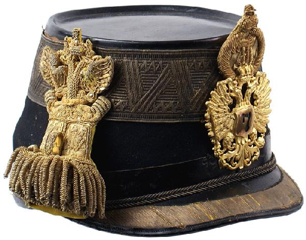 Austrian Major Staff Officer shako helmet: E-12 Major Staff Officer shako. Blue felt body with a 1 7/8" wide, linear designed, gold band around crown. 1" wide black leather band around base. Relief 3/4" gold wire border on black leather brim. 
