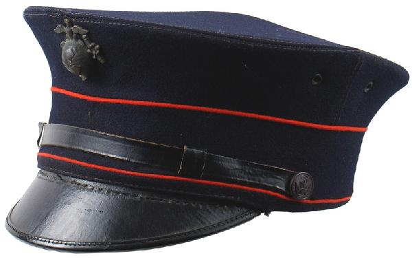 U.S. Marine Corps M1912 peaked cap: E-176 Marine Corps M1912 peaked cap. Blue wool body with a red piped band. Black leather visor and chinstrap with proper side buttons. Aged darkened brass EGA badge. Tan leather sweatband with pencile