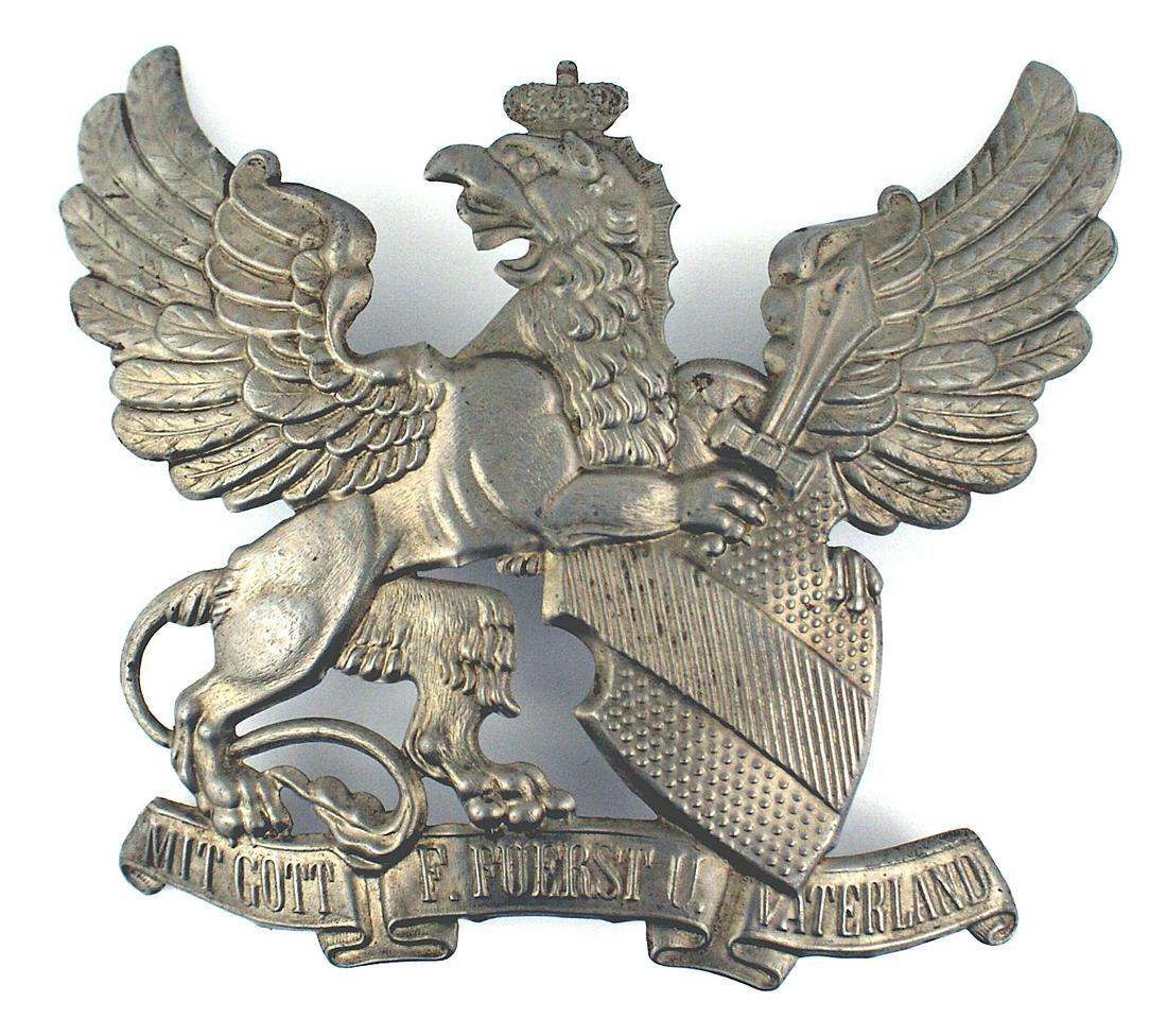 Imperial Baden pickelhaube helmet plate: E-030 Imperial Baden other ranks "pickelhaube" helmet plate. Gray metal griffen holding a sword and state shield. Legend with "MITT GOTT F. FUERST U. VATERLAND". Two metal fastening loops on reverse. 