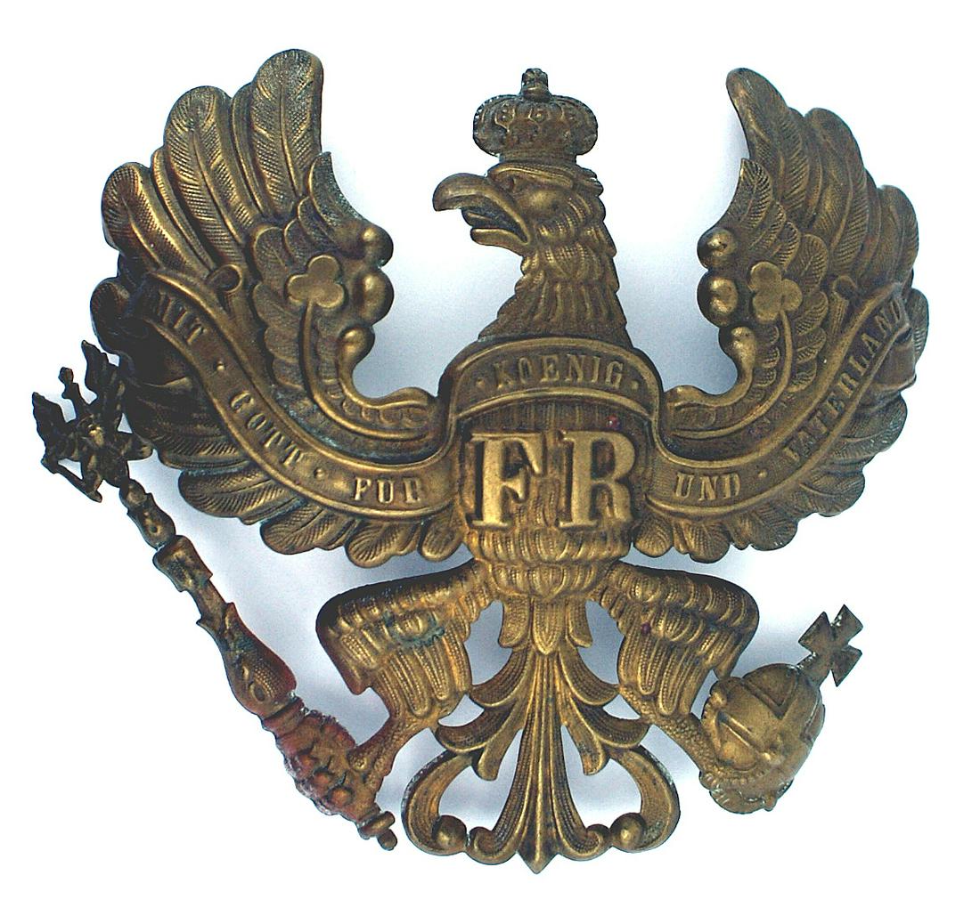 Imperial Prussian EM brass helmet plate: E-032 Prussian other ranks E.M. brass helmet plate. Crowned eagle with "FR" on chest with a legend "MIT GOTT FUR KOENIG UND VATERLAND" and holding a scepter and orb. One wire loop on reverse. 4 1/4" x
