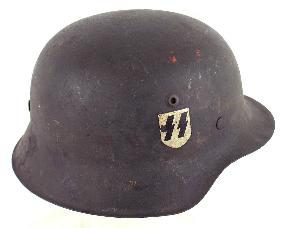 German WWII Waffen SS M1942 helmet: E-057 German WWII Waffen-SS M 1942 single decal helmet. 85% original OD finish with some wear and black stain on back of skirt. 95% "SS" decal. Tan leather drawstring liner is torn and shows wear exte
