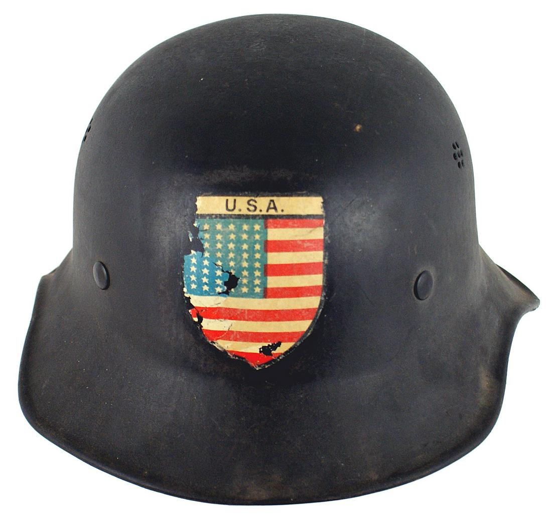 German WWII one piece Luftschutz helmet: E-069 German one-piece Luftschutz helmet. Dull black finish with a post-war 1945 "USA"/American flag shield decal applied to the front (several small scratches). Fiber drawstring liner and a plastic c