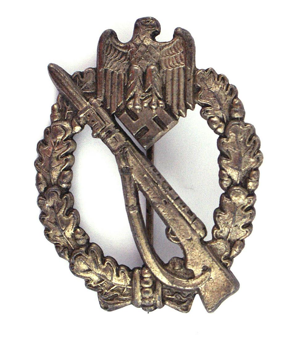 German WWII Infantry Assault Badge: B-061 Infantry Assault Badge - Silver. Convex shape. Rifle with fixed bayonet on an open oak leaf wreath with an eagle/swastika at the top. Reverse: marked "JFS". II