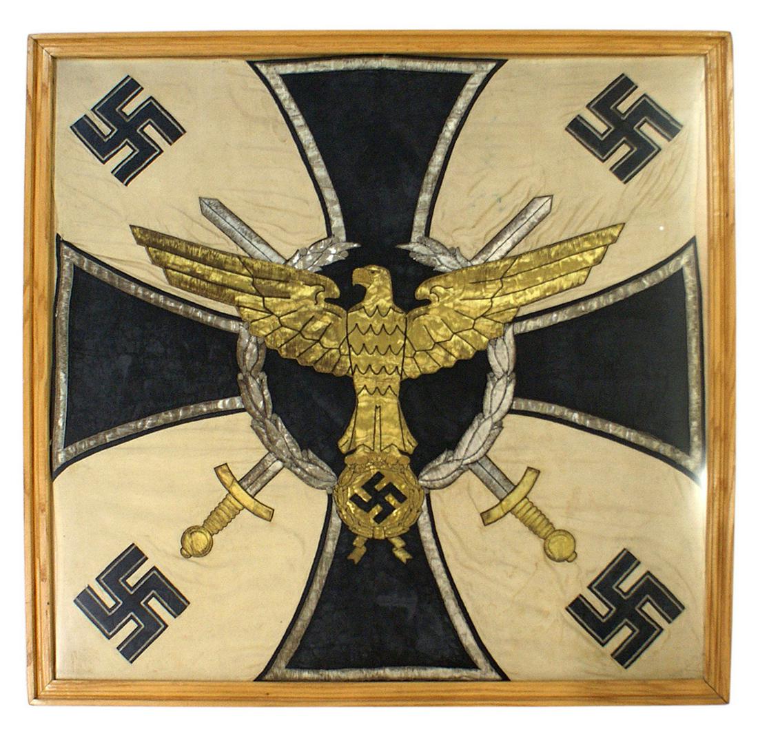 German WWII regimental standard: A-032 Unusual Third Reich standard. Large gold eagle, with out - stretched wings perched on a gold oak leaf roundel, holding an embroidered black swastika. Background consists of a 43" x 43" Iron Cros