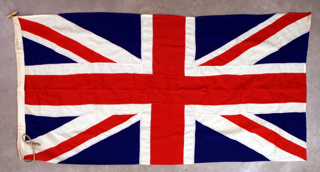 British Union Jack flag: H-132 British Union Jack. All separatley sewn color sections. 3' x 6'. Cloth instructions for care label on fly. Wood "barrel" attachment and rope tie. II