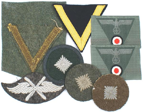 Lot of German WWII cloth insignia cap uniform: H-65 Lot of cloth insignia: (1) Two Army bevo M1943 trapezoid eagle/rosette cap insignia. Uncut. (2) Three different Army Oberschutz rank roundels. (3) Luftwaffe Flying Personnel sleeve badge. (4) Two