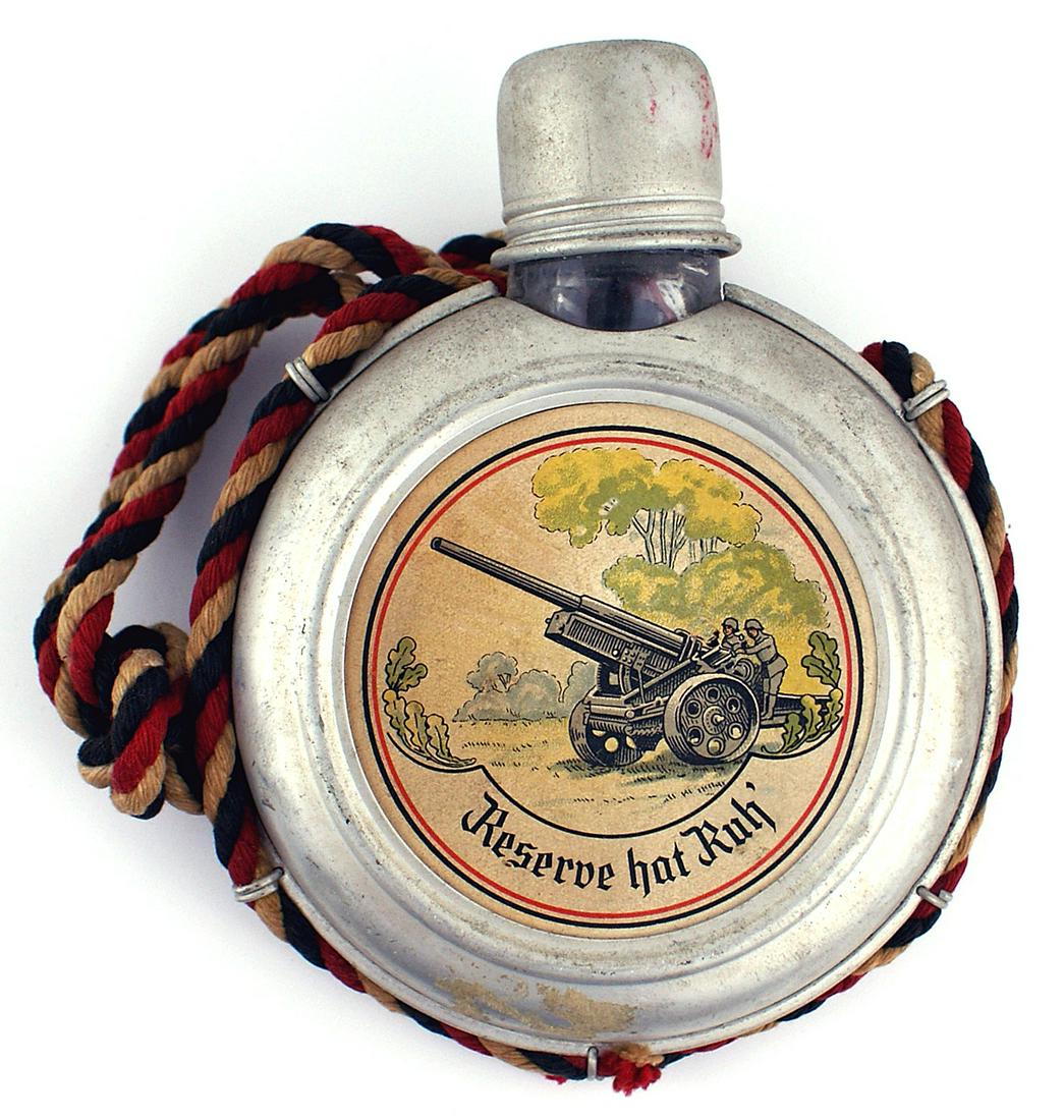 German early 1930s souvenir flask: G-008 German early 1930's souvenir flask. Round flat 5 1/2" diameter glass canteen encased in an aluminum frame. Screw on matching metal cup/lid. Large paper center with a helmet, oak leaves and "Wehr