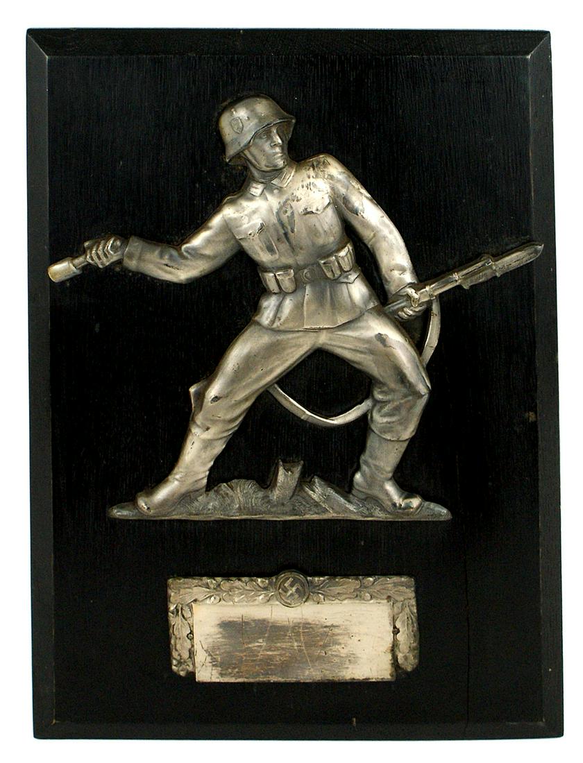 Helmeted WWII German Soldier plaque grenade: G-016 Age toned 7 1/2" x 8 3/4" silvered relief figure of a helmeted WWII German Soldier holding a rifle with fixed bayonet and throwing a "potato masher" hand grenade. 1 7/8" x 4 1/2" honor award pla