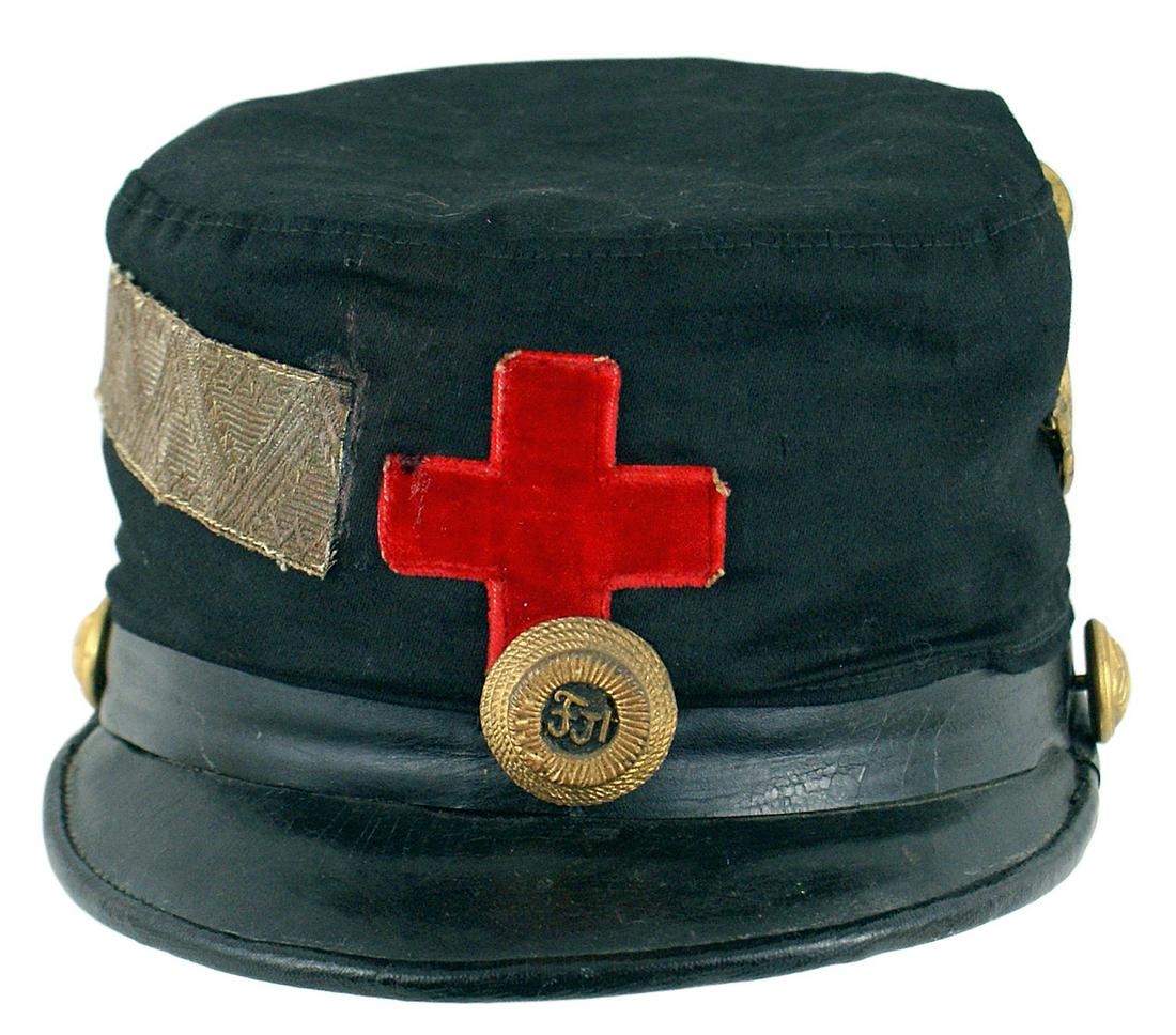 Imperial Austrian Red Cross shako: E-010 Imperial Austrian Red Cross shako. Black cloth covered "hard" body. 2" x 2" red valour Geneva Cross and period age toned "FJ1" on a "rope" type roundel - on front. Original Tyrolean Jager eagle/