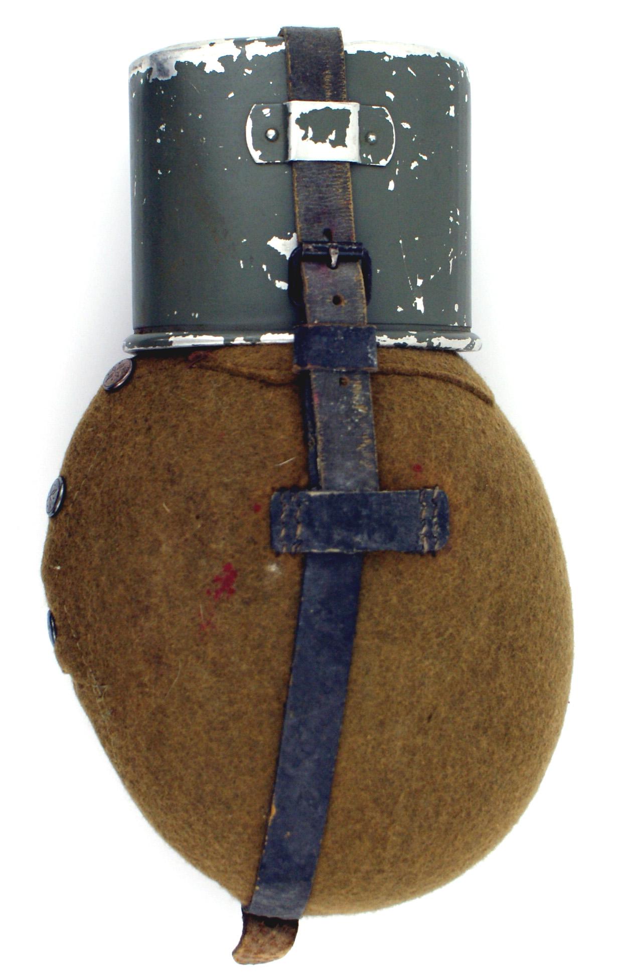 German WWII Army canteen: N-005 German WWII Army canteen. M1931 aluminum with a button snap felt cover. 75% O.D. paint remains on the metal cup. Leather strap with belt strap. II