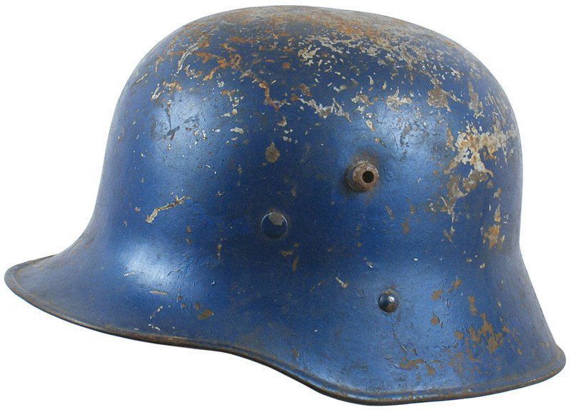 Austrian WWI M1916 helmet: E-12 As above. Similar to the German M1916, but the liner band side rivet and chinstrap post rivet are closer to each other. Painted blue. No liner or chinstrap. III