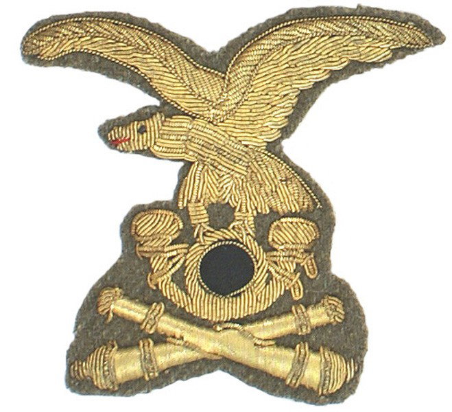 Italian WWII Alpini Artillery cap eagle: E-84 Italian WWII Alpini Artillery cap eagle. Gold bullion spread-winged eagle/horn (black cloth center)/crossed cannons - on an olive-brown field. 3 ½" x 3 ½". I