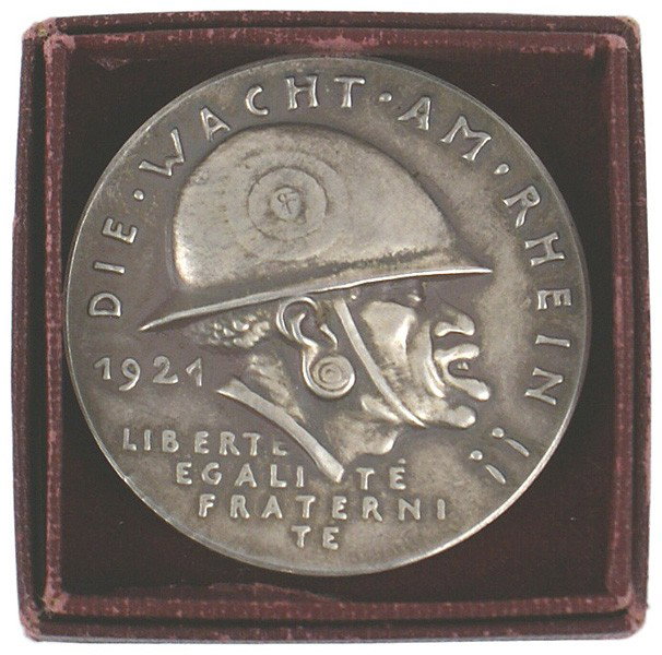 German 1921 Anti-French commemorative medal GOETZ: B-17 "DIE WACHT AM RHEIN!". Silver 1921 Anti-French commemorative table medal. Obverse bears an uncomplimentary profile of a helmeted French colonial soldier. Reverse has biting commentary of the post