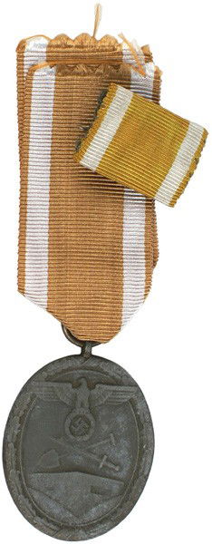 German WWII Westwall Medal with ribbon: B-88 Westwall Medal with ribbon. Large eagle/swastika/crossed shovel/sword above a bunker. Awarded to all personnel who helped construct Germany's West Wall fortifications. 50% of finish is worn. With