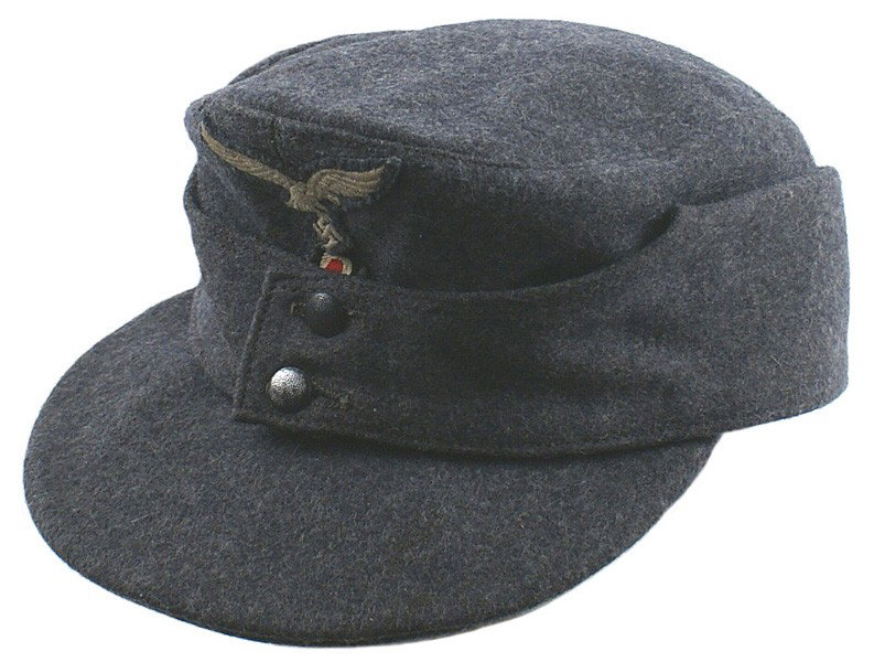 German WWII Luftwaffe M43 EM Cap: E-103 German WWII Luftwaffe M43 EM. Cap. Blue-gray "ersatz" material with a hand sewn eagle/swastika above a bevo rosette. Satin lining is numbered and dated "1944". II+