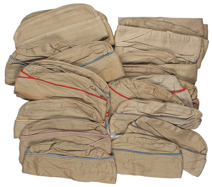 Lot 28 U.S. WWII Army oseas summer caps: E-130 Lot of 28 U.S. WWII Army o'seas summer caps. Most have color piping (red, blue, white and maroon, orange and white, etc.). With tags "COMBAT SERVICEABLE", "FORT DIX" etc. Variables in bundles. A