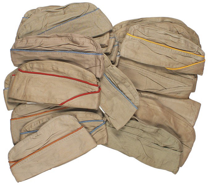 Lot 28 U.S. WWII Army oseas summer caps: E-132 Lot of 28 U.S. WWII Army o'seas summer caps. Most have color piping (red, blue, white and maroon, orange and white, etc.). With tags "COMBAT SERVICEABLE", "FORT DIX" etc. Variables in bundles. A