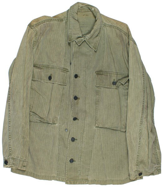 POW worn tunic: F-85 POW worn tunic. Similar to above - but with longer pockets. Large "PW" on back is faded but still discernible. Wear on ends of cuffs. About II