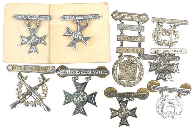 Lot of 10 USMC STERLING shooting badges: B-217 Lot of 10 U.S.M.C. "STERLING" shooting qualification badges: (1) 5 - "PISTOL SHARPSHOOTER". (2) 2 - "PISTOL EXPERT", (3) "RIFLE SHARPSHOOTER", (4) "RIFLE EXPERT" and (5) WWII "U.S. MARINE CORPS"