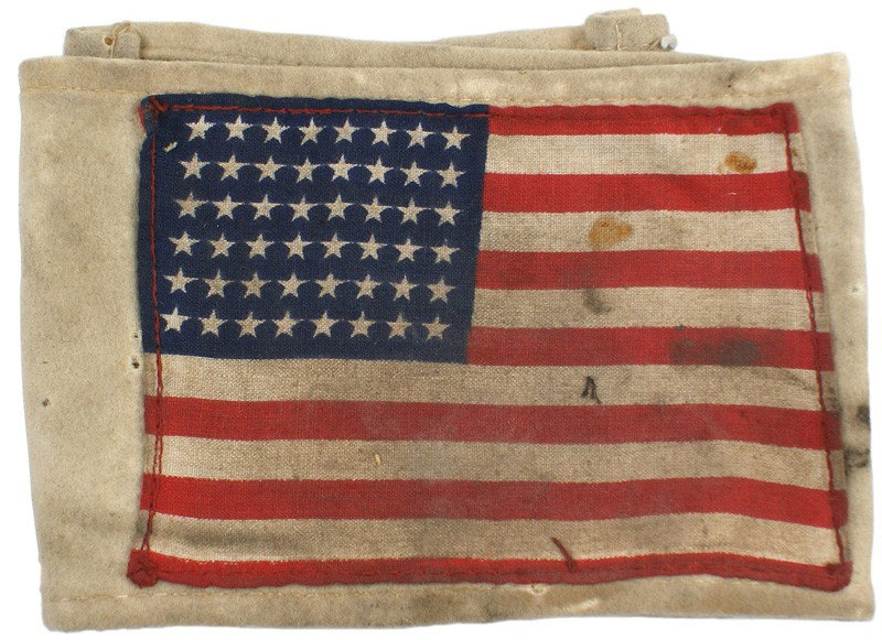 U.S. WWII D-Day Invasion armband: H-281 D-Day Invasion armband. 3 ½" x 4 7/8". 48-star American flag sewn to a heavy white felt type 4" wide cloth band. Discolored from use and age. About II