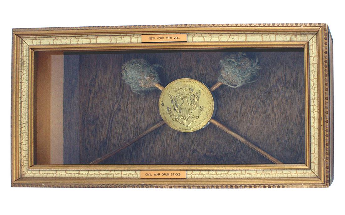 American Civil War bass drum beaters sticks: K-040 American Civil War bass drum "beaters". 11 1/4" wood rods with yarn wrapped twine heads. Mounted with a brass eagle decorator sword holder in a 10 3/4" x 21" x 5" shadow box. Shows some wear fro