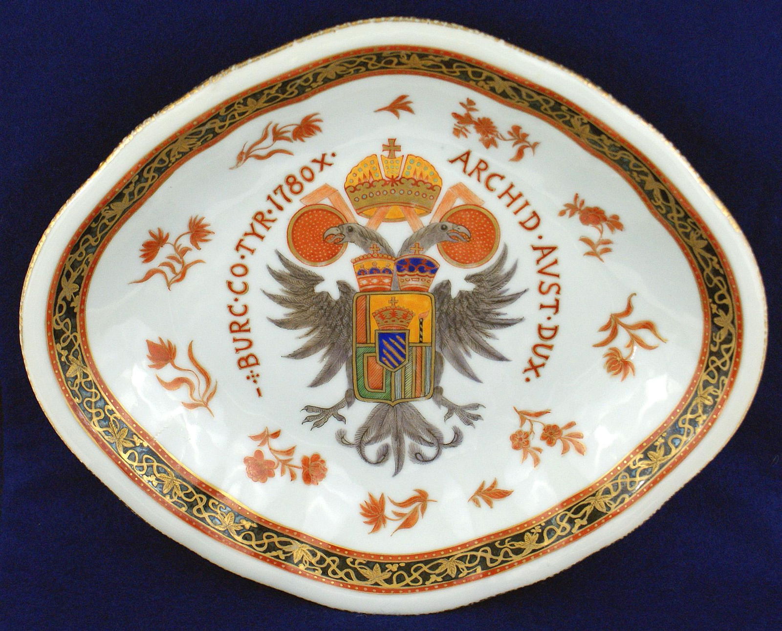 Platter acquired at Hitler's Berghof Austrian eagle: A-053 Unusual rounded corner, diamond shaped, decorated porcelain serving platter. Red outlined black perimeter with gold leaf floral decorations. Center of 1 1/2" deep dish bears a quality multi-colo