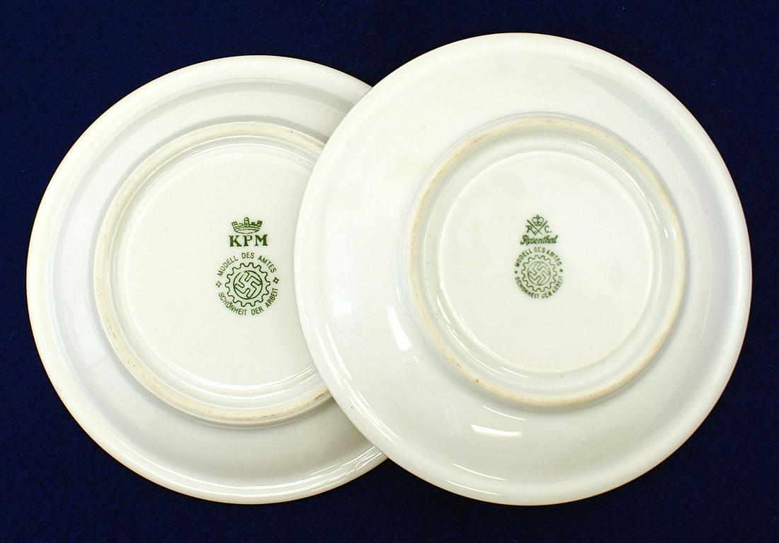 German WWII DAF porcelain saucers: H-144 Third-Reich lot of 2 DAF (German Labor Front) messhall white porcelain saucers. 6" diameter. Underside with maker "Rosenthal" logo and DAF cogwheel with a swastika, the other made by "KPM". II+
