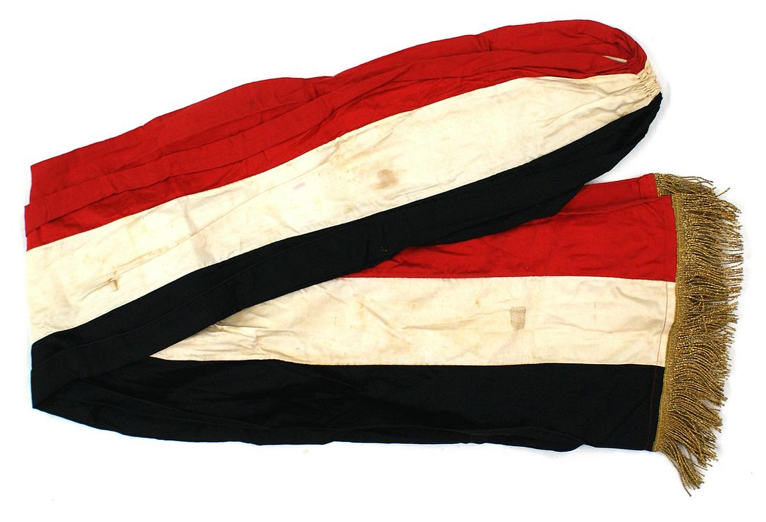 Traditional German National Colors parade sash: H-152 Traditional German National Colors (black/white/red) drum majors parade sash. 9" wide ribbon with a gold wire fringe on each end. 48" length. II