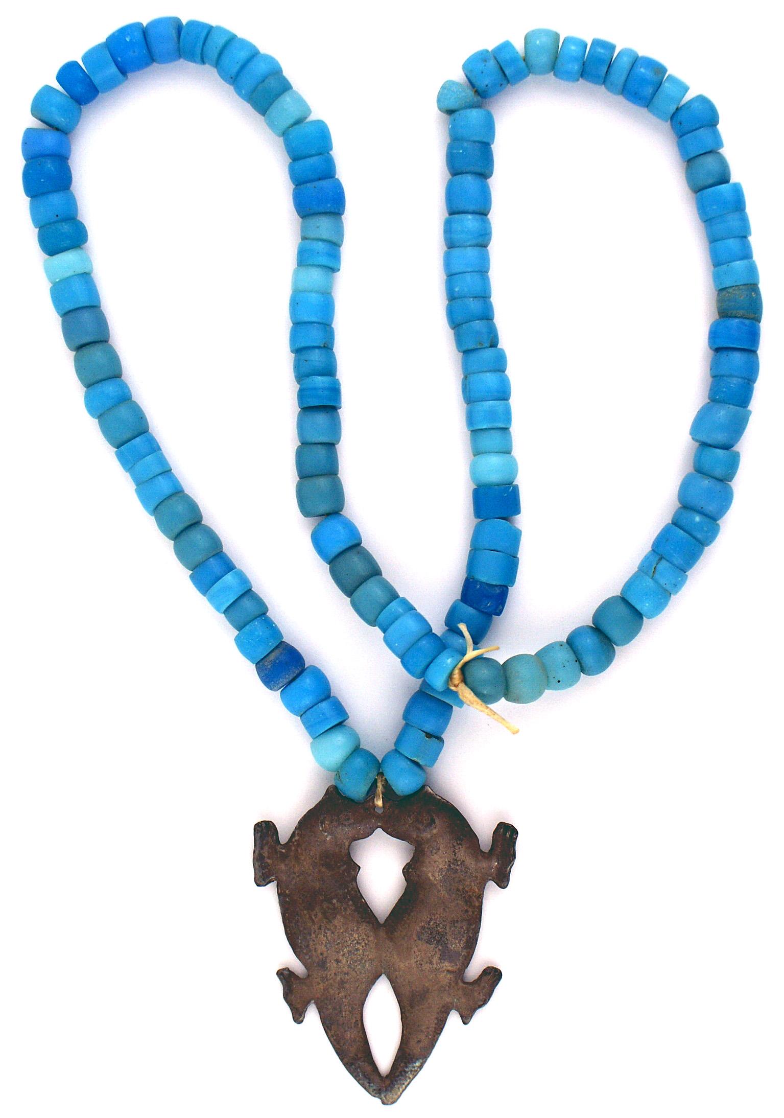 American Iroquois Indian kissing otter trade necklace: R-008 American Iroquois beaded "kissing otter" trade necklace. Fully strung blue beads, showing several different shades. The reverse of the cast pewter "kissing otters" shows some age and appears to 